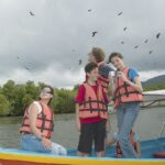 sekumpulan keluarga sedang duduk di bot sambil meikmati trip island hopping langkawi