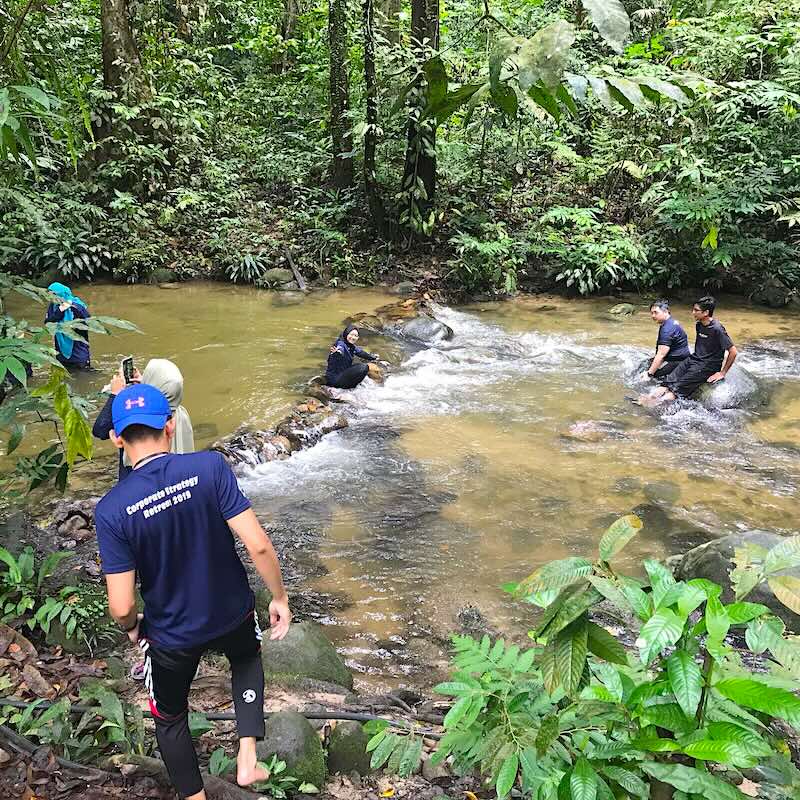 sekumpulan pemuda pemudi sedang duduk di sungai congkak semasa trip ke skytrek sungai congkak
